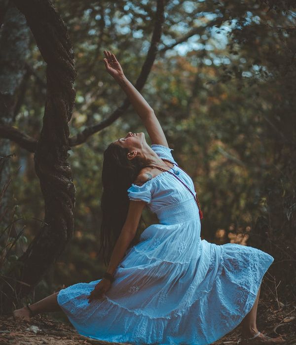 Woman performing a graceful stretching exercise in nature.